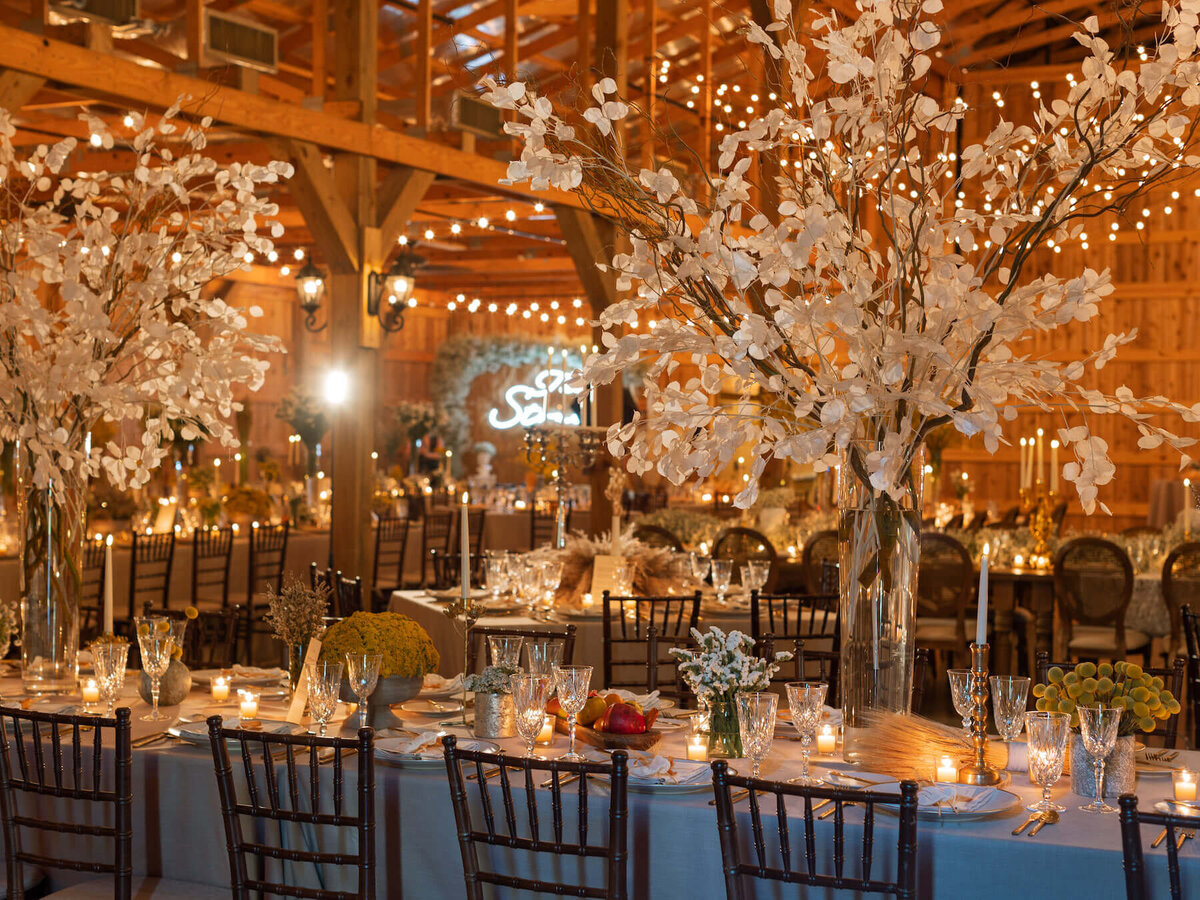 White lunaria centerpieces at boho barn wedding reception