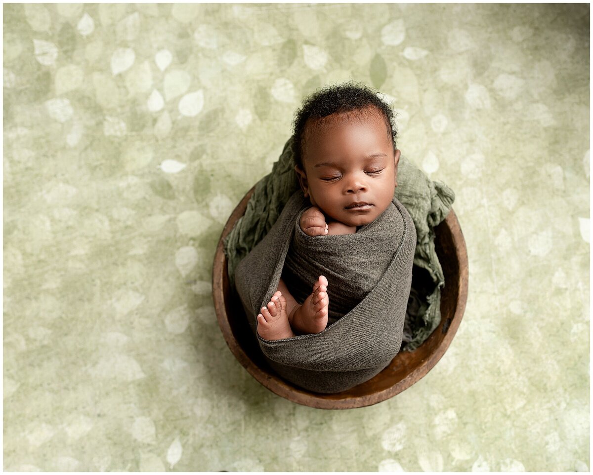 A newborn baby swaddled in a cozy wrap , showcasing their adorable chubby cheeks and peaceful expression.