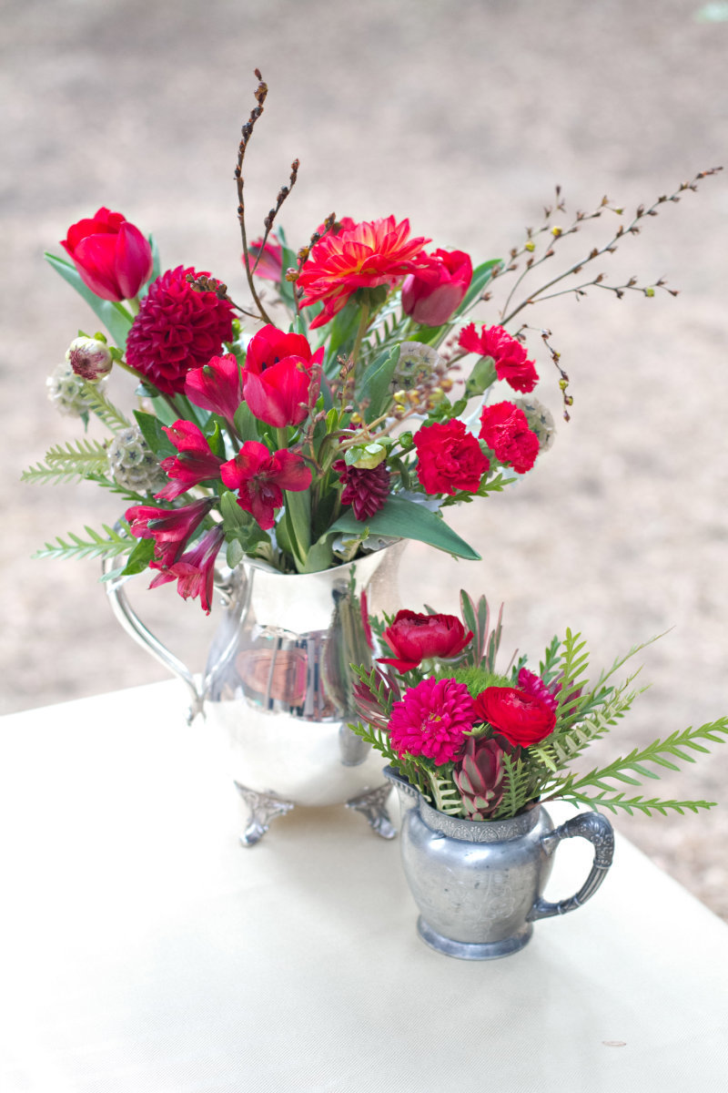 Red flowers in a silver teapot and creamer for wedding brunch