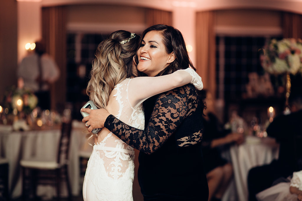Wedding Photograph Of Bride Hugging a Woman In Black Dress Los Angeles
