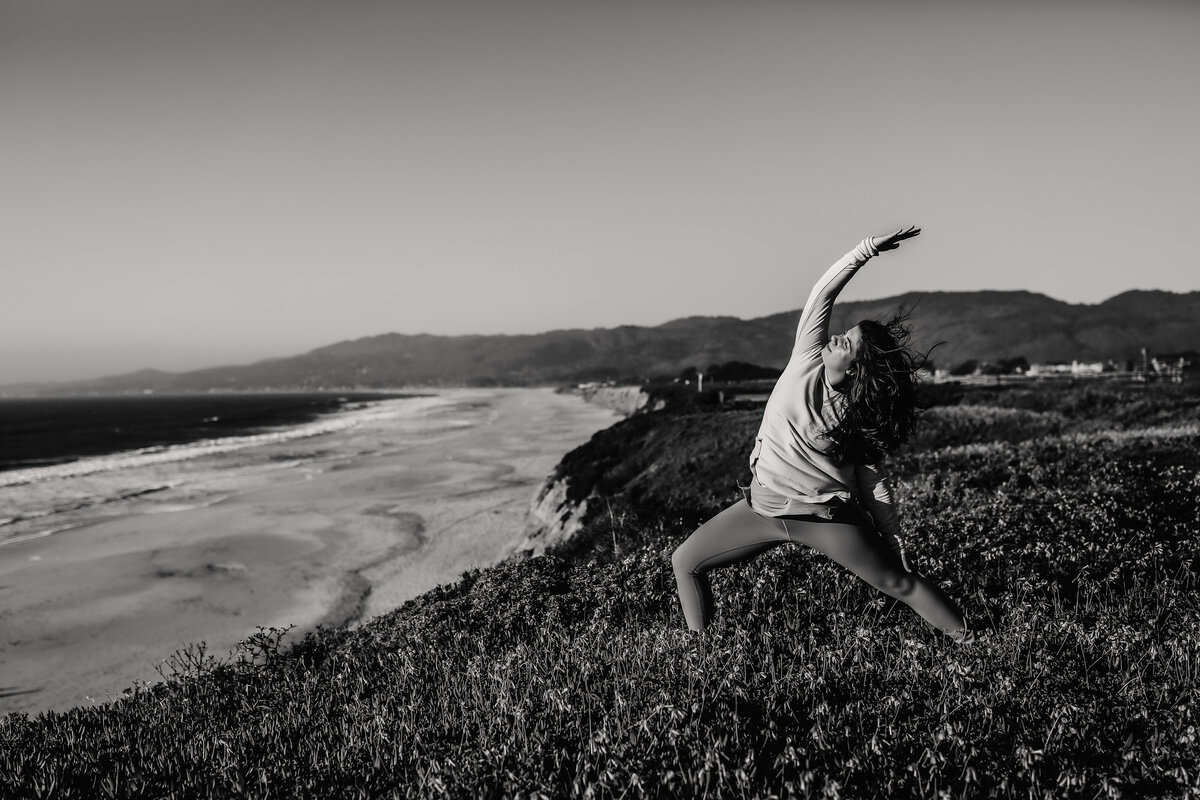 Lifestyle headshot in black and white of bay area yoga instructor doing yoga on San Francisco coast