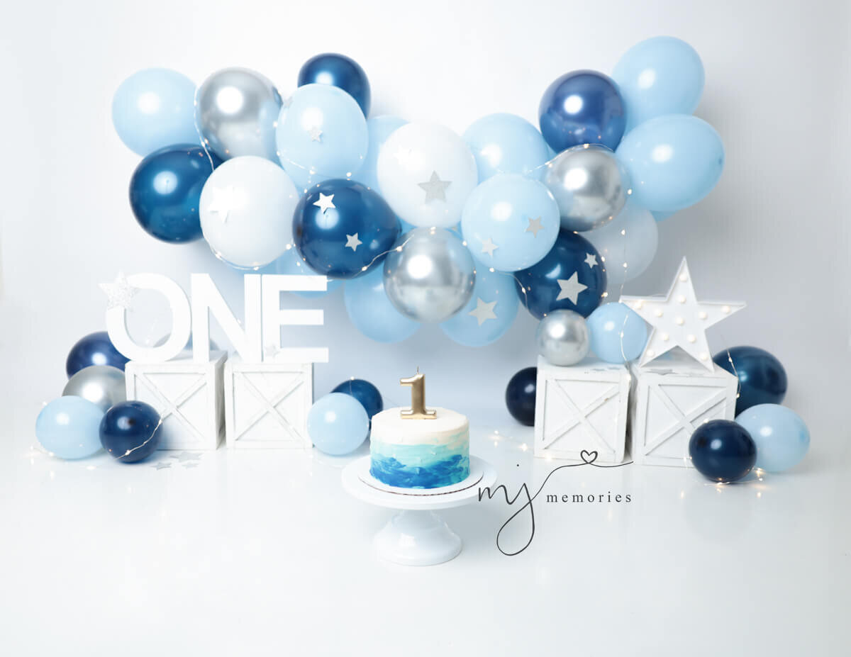 Creative arrangement of balloons and a beautifully designed cake for a custom cake smash photography session in Rochester, NY.