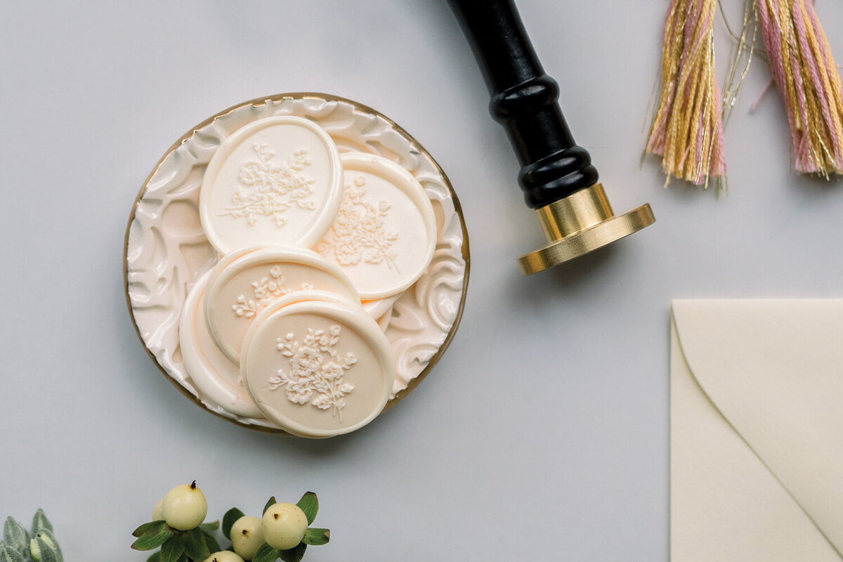 Detailed shot of yellow floral oval wax seals used on letterpress invitations for a pink and yellow girl baby shower.