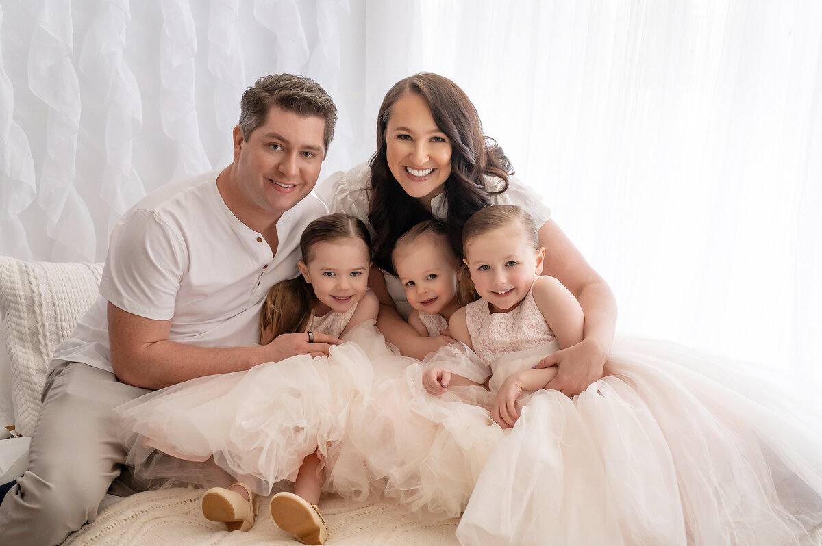 A family of five snuggle up in our Waukesha, WI photography studio  for a family portrait.