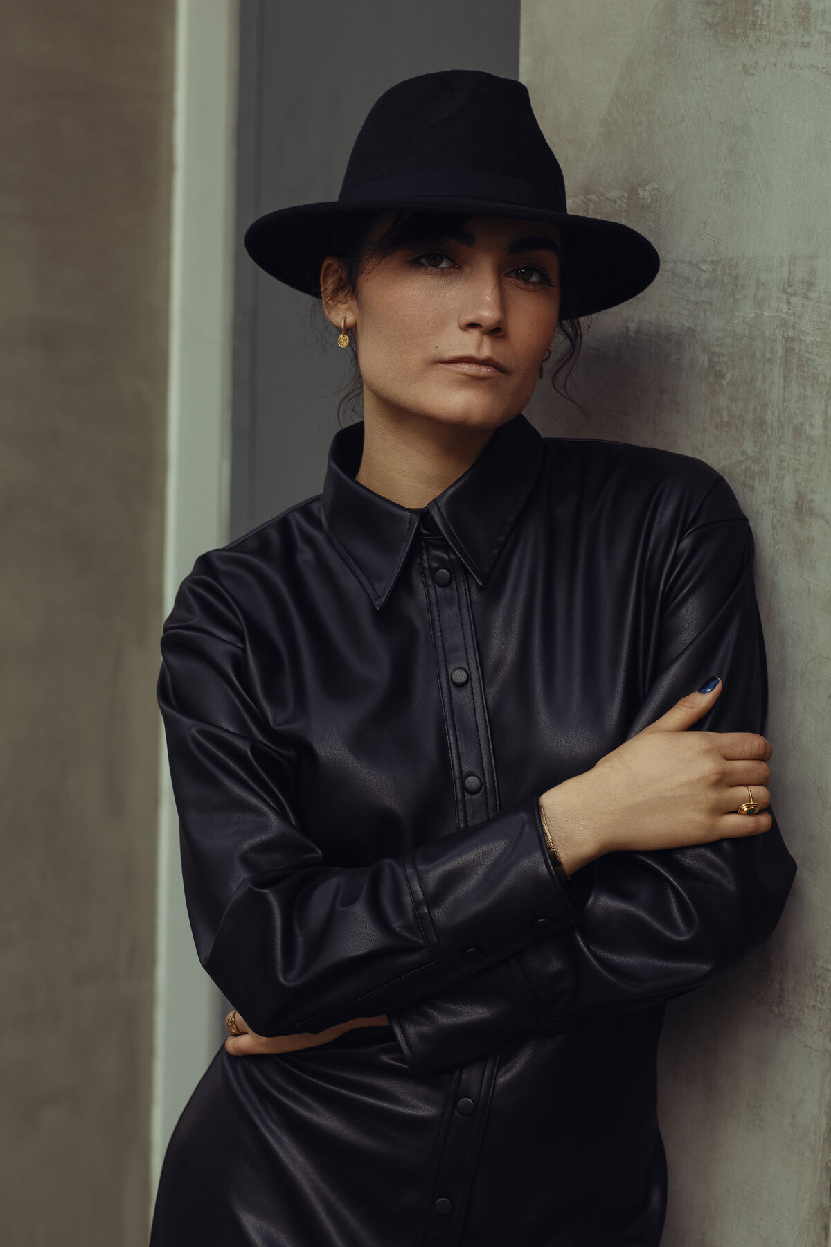 Portrait Photo Of Young Woman In Black Leather Coat With One Hand Touching Her Elbow Los Angeles