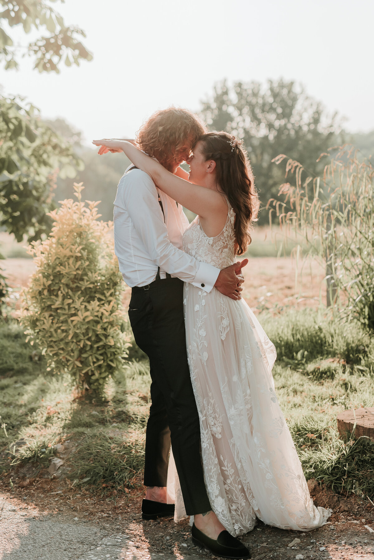 Bride & Groom kiss during golden hour at their barn wedding at Oak Tree Barn Weddings
