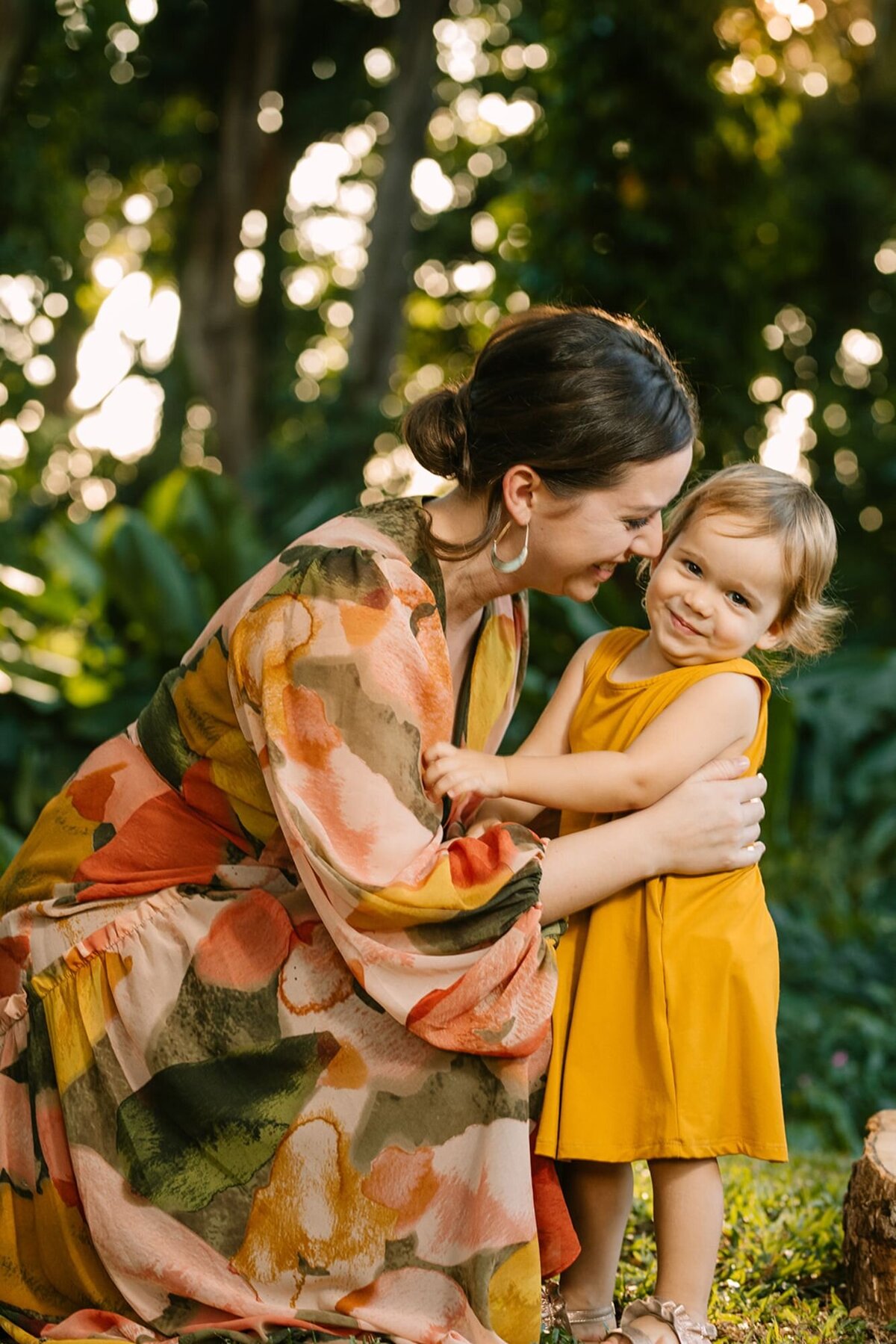 mom and toddler daughter hug during an oahu family photo session