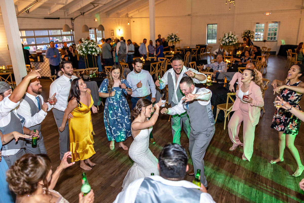 bride and groom dance surrounded by guests with stage light at Morgan Creek Barn in Dripping Springs