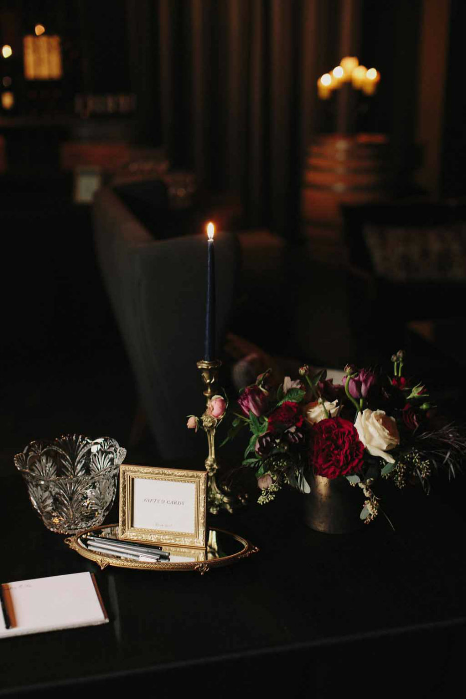 Moody, dramatic wedding with black candles and dark red floral.