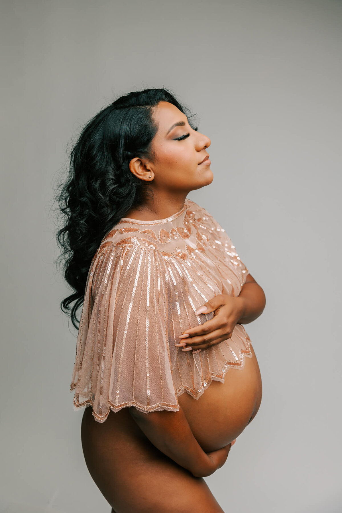 mom wearing gold cape in studio maternity photography portrait