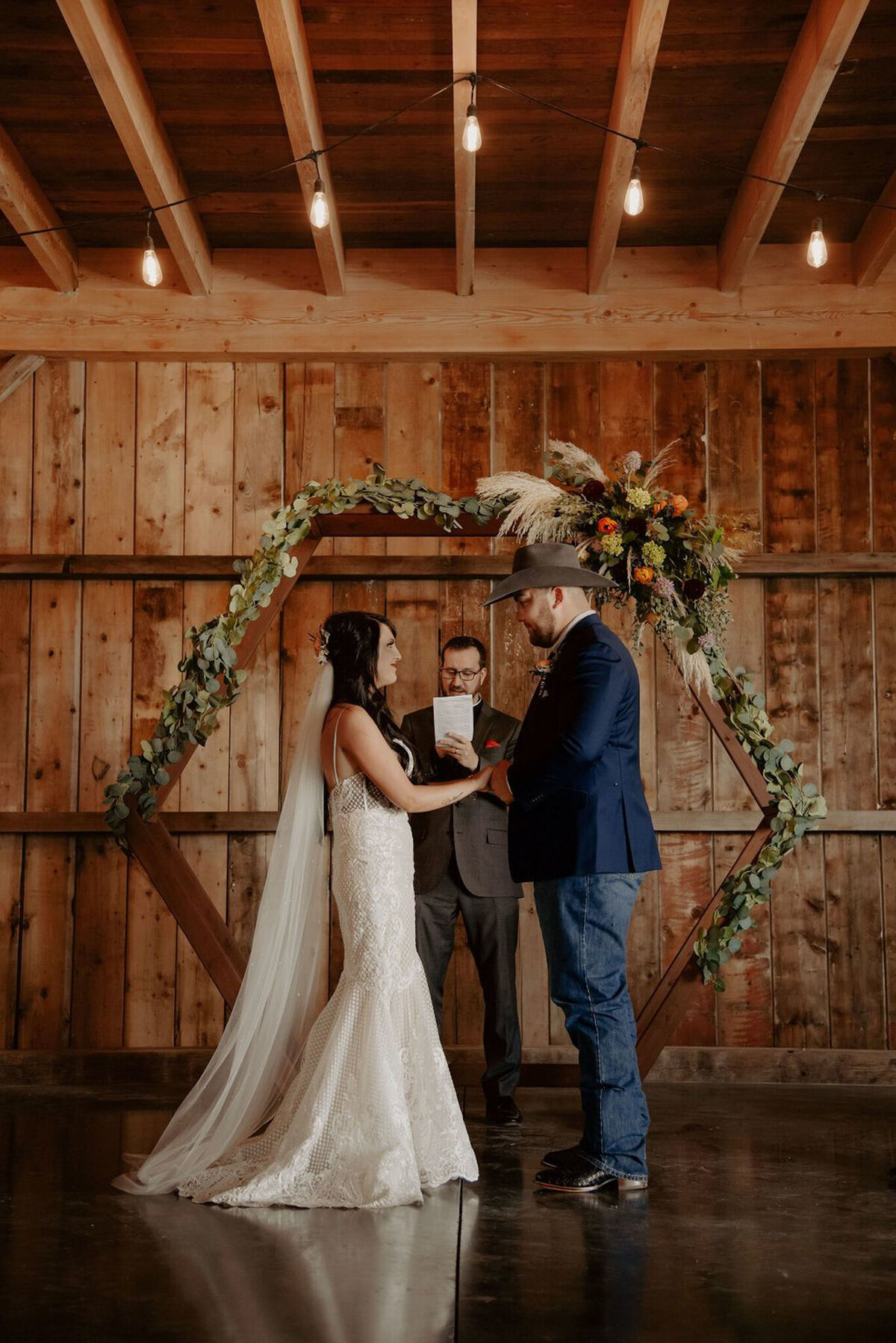 Indoor rustic wedding ceremony at Countryside Barn, rustic, country Lethbridge, Alberta wedding venue, featured on the Brontë Bride Vendor Guide.