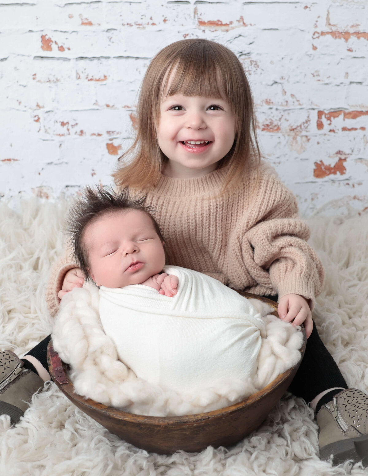 Big sister holding baby brother at our Hilton, Ny studio.