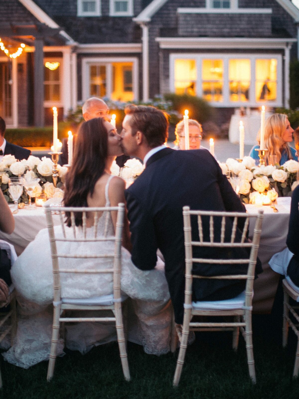 Groom Kissing Bride at Reception Table