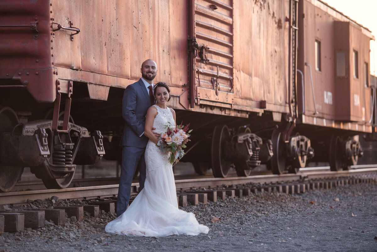 bride and groom standing in front of train at Maritime Parc