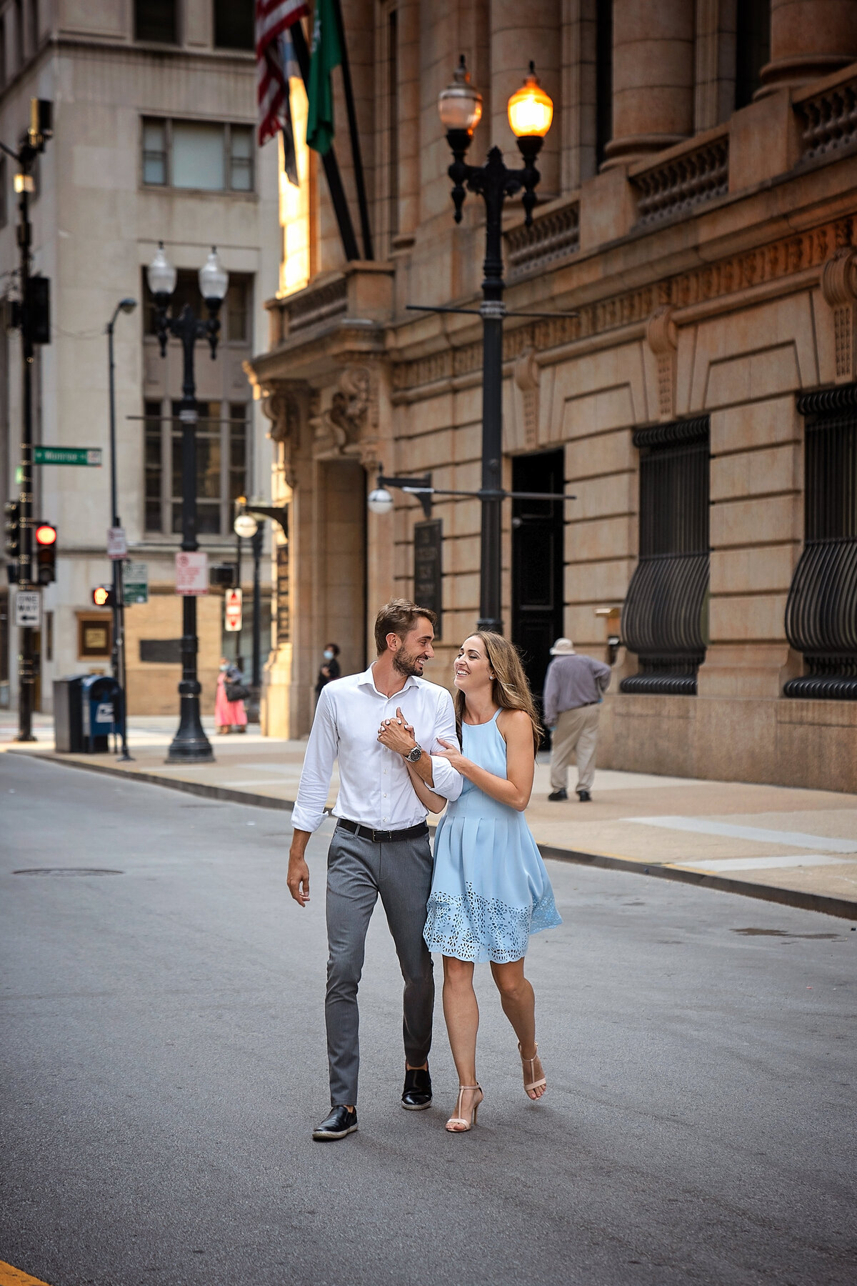 Engaged couple crossing  Chicago busy street  near trade building