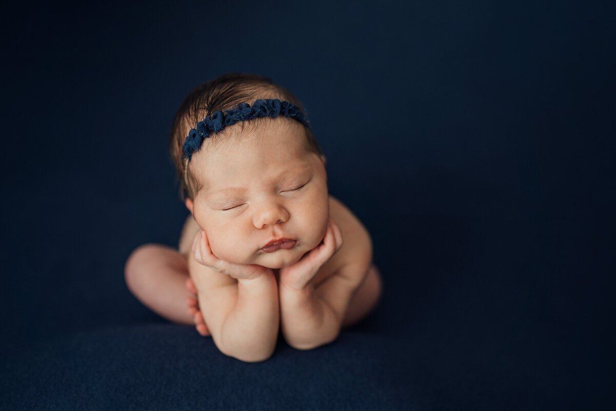 newborn girl doing froggy pose in st. pete photography studio