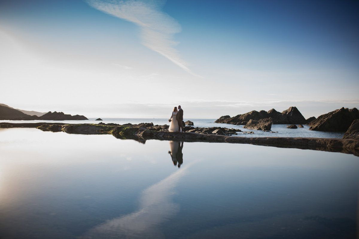 Bride and Groom reflected in the tidal pools Tunnels Beaches Devon