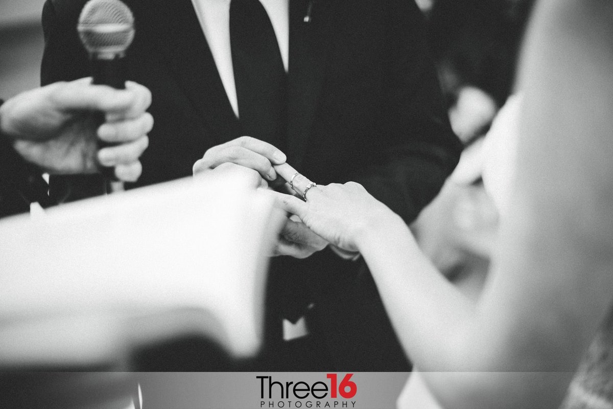 Groom placing ring on to his Brides finger