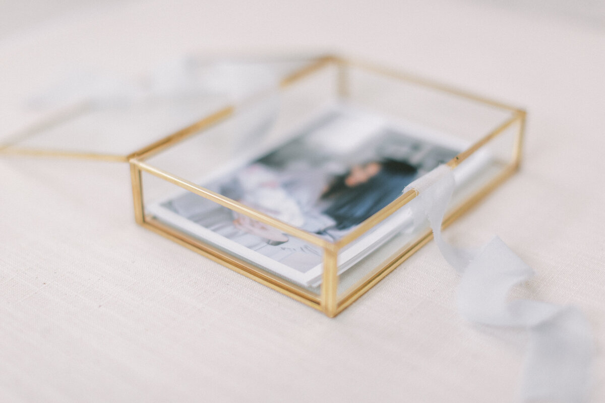A glass box of proof prints surrounded by light blue ribbon