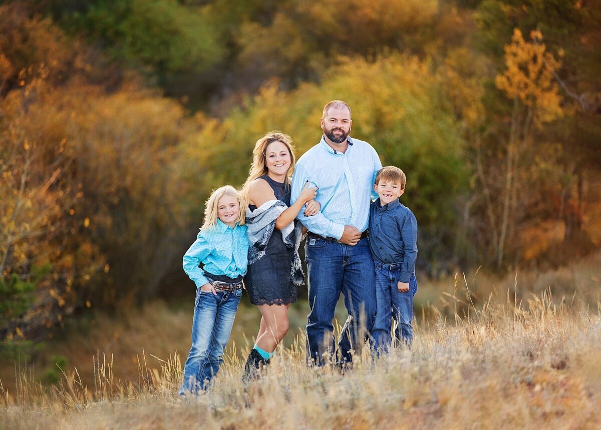 A family picture session by laramie in front of beautiful fall leaves.