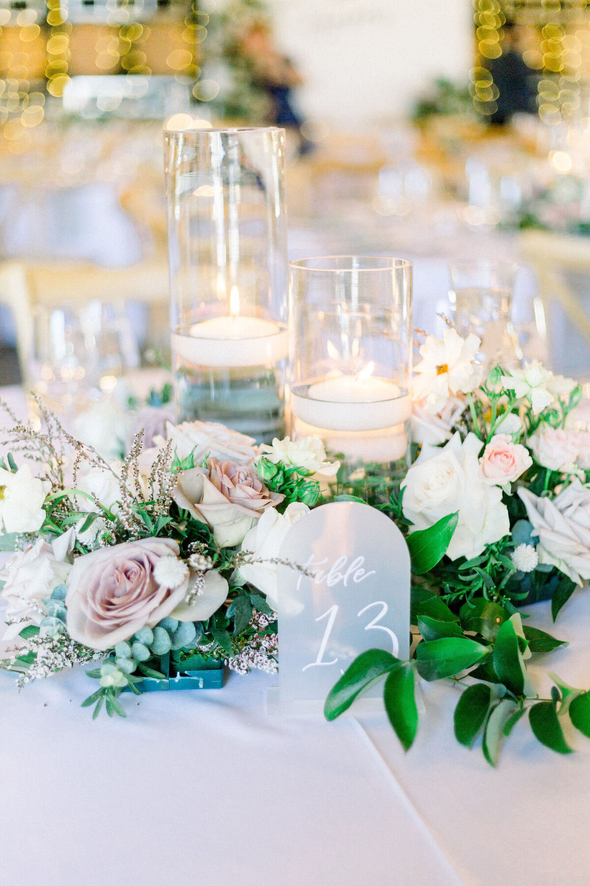 Floral tablescape with roses, candles, and an arched table number