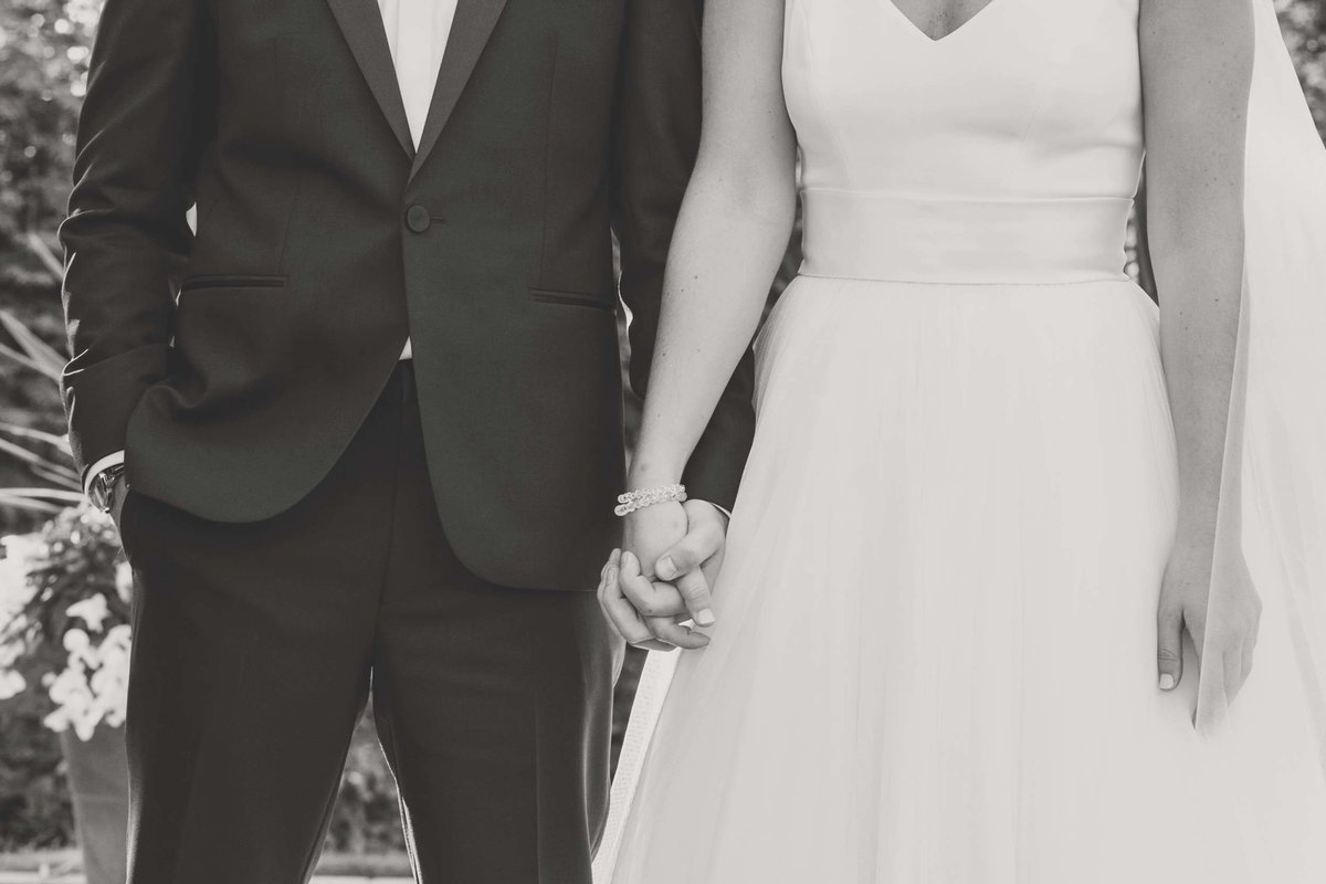 Close up of bride and groom holing hands in black and white at Stonebridge Country Club