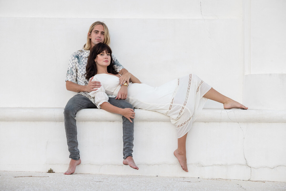 A young couple posing on a bench area in Alys Beach Florida.