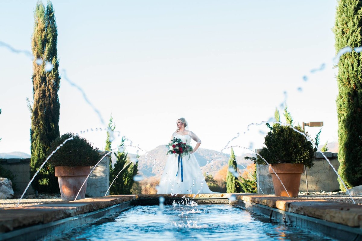 Wedding Photographer, bride standing next to pool and fountains
