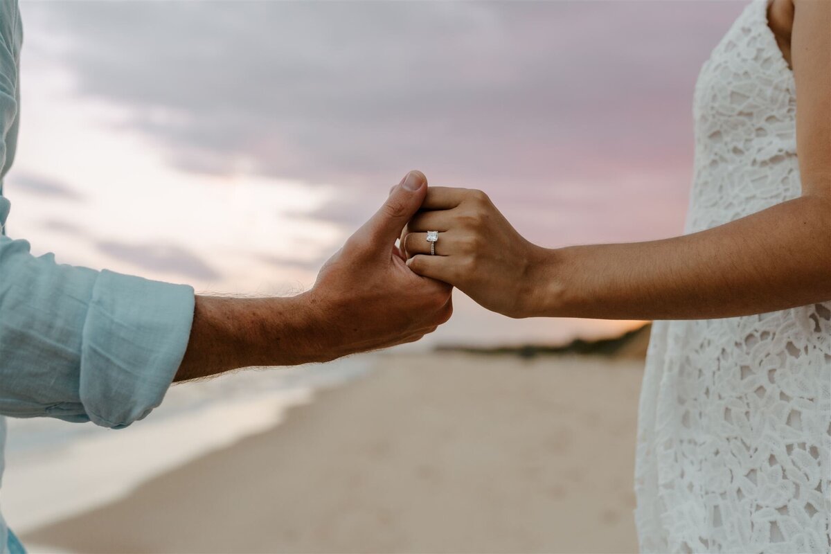 couple holding hands during beach engagement photography