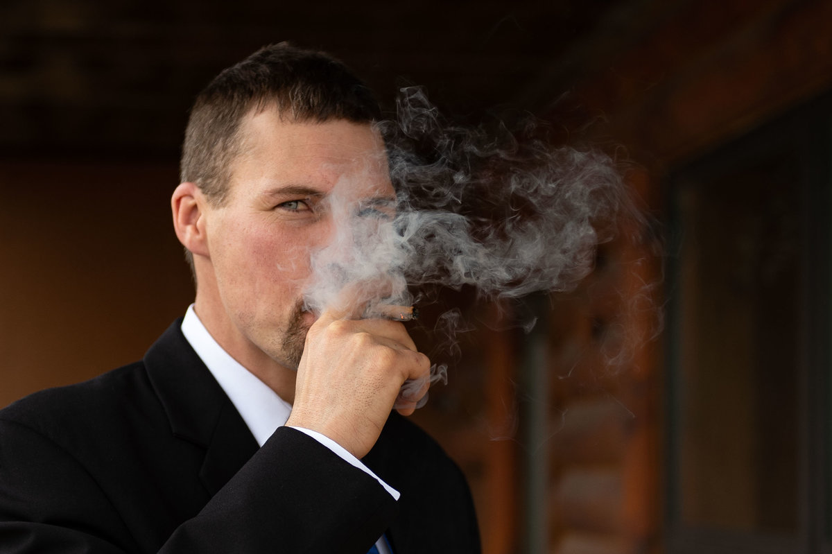 guest steps out for cigar pic with smoke
