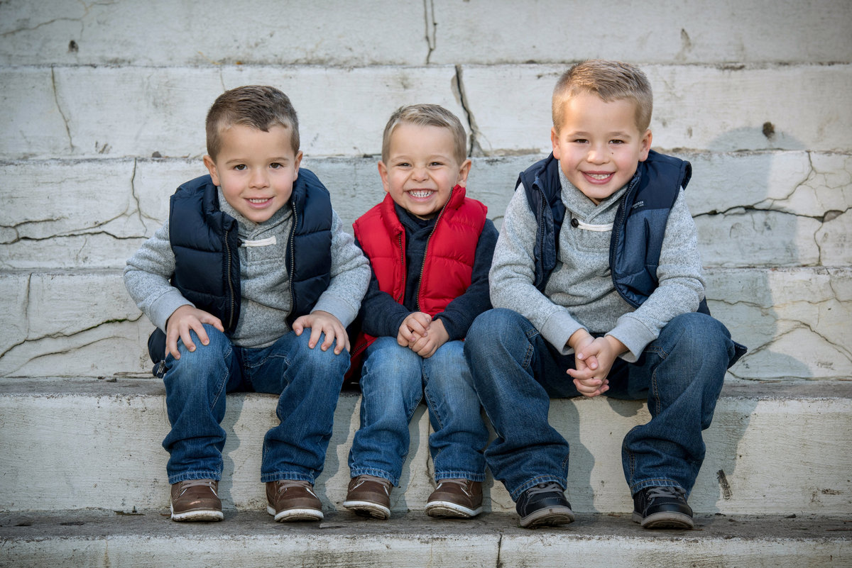 Three cute boys grinning for a portrait together on step at Cantigny Park