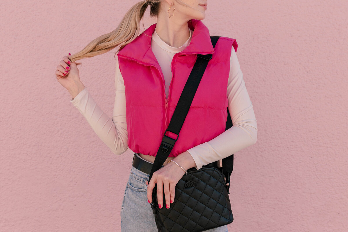 Sporty Barbie Model looks off over her shoulder while holding a black purse and the end of her ponytail