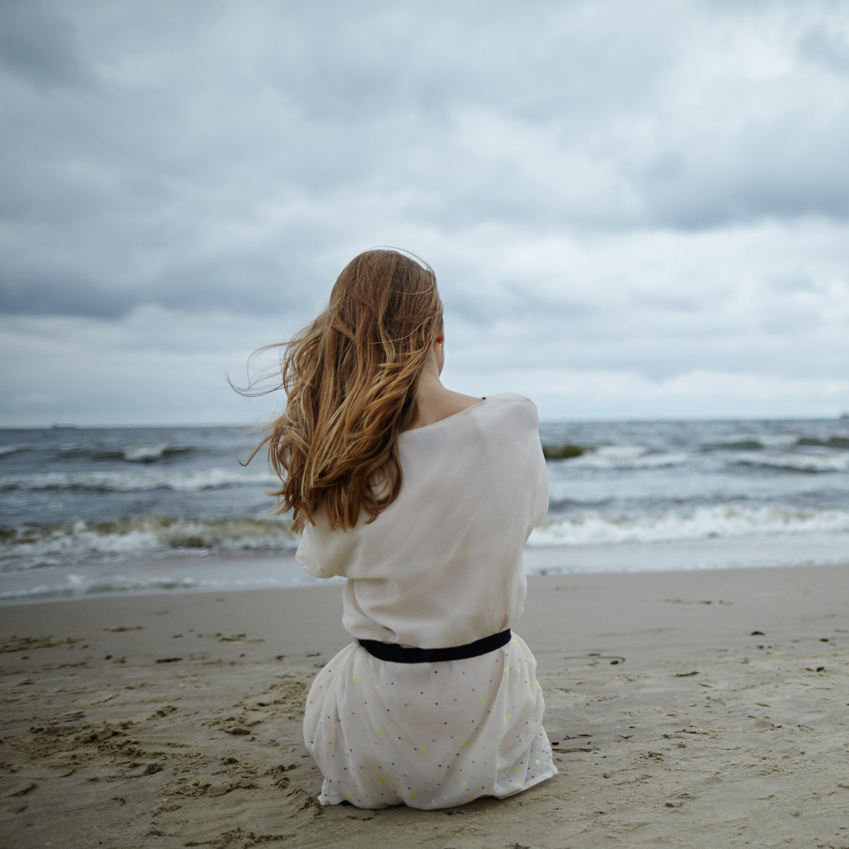 young-beautiful-woman-on-cold-windy-beach-PVBFV9R