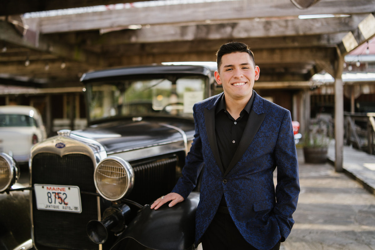 high school guy posing with classic car in San Antonio by high school senior photographer