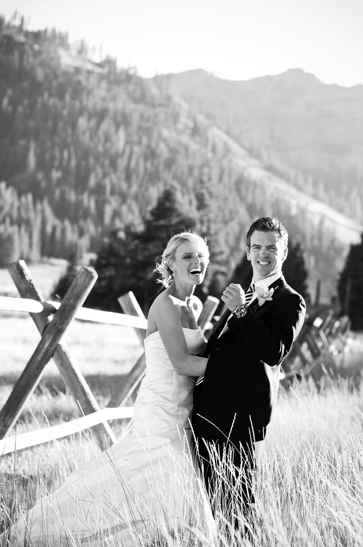 Couple cheering while posing at a wedding in Palisades tahoe. Black and white image