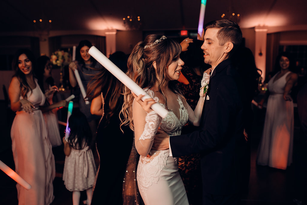 Wedding Photograph Of Bride Holding a Light Stick While Dancing With Groom Los Angeles