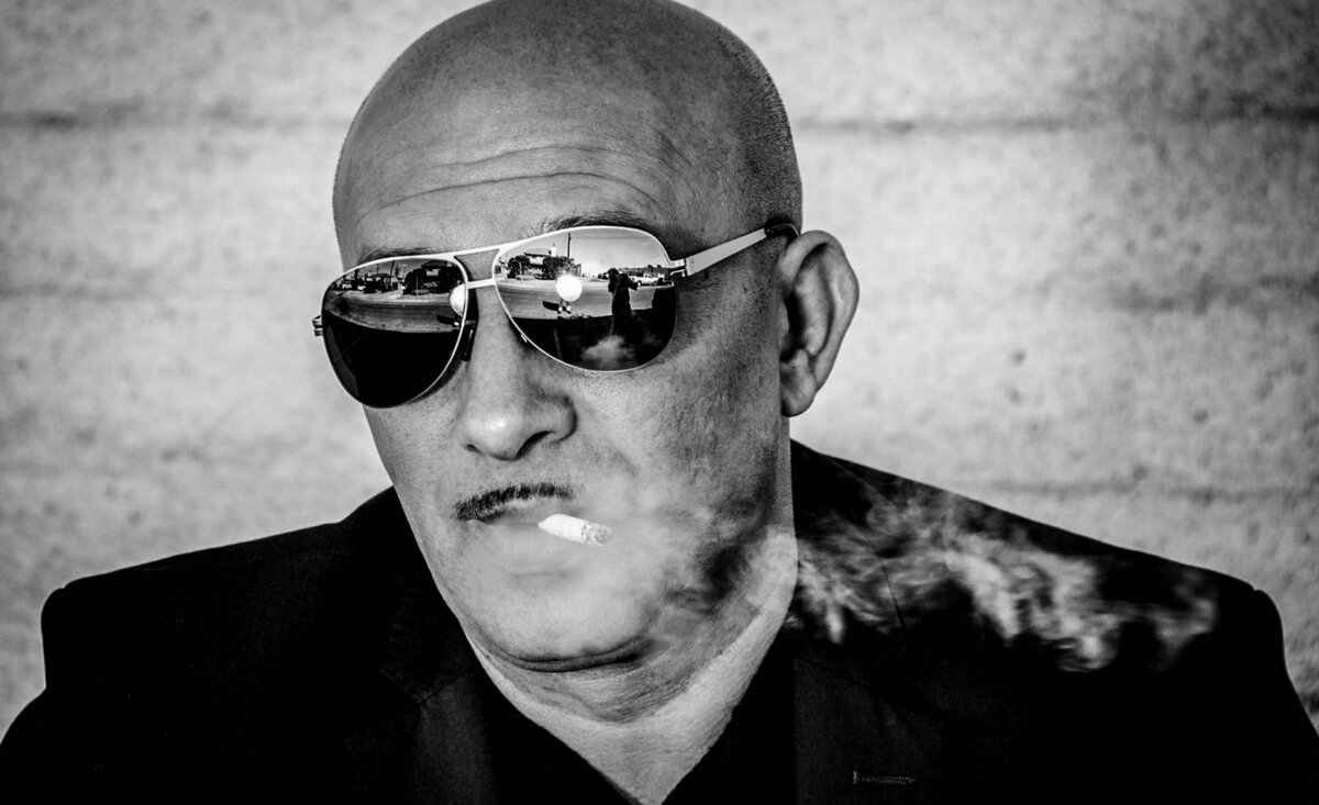 Male musician portrait Paul Lakatos black and white wearing sunglasses smoke from cigarette blowing out of mouth