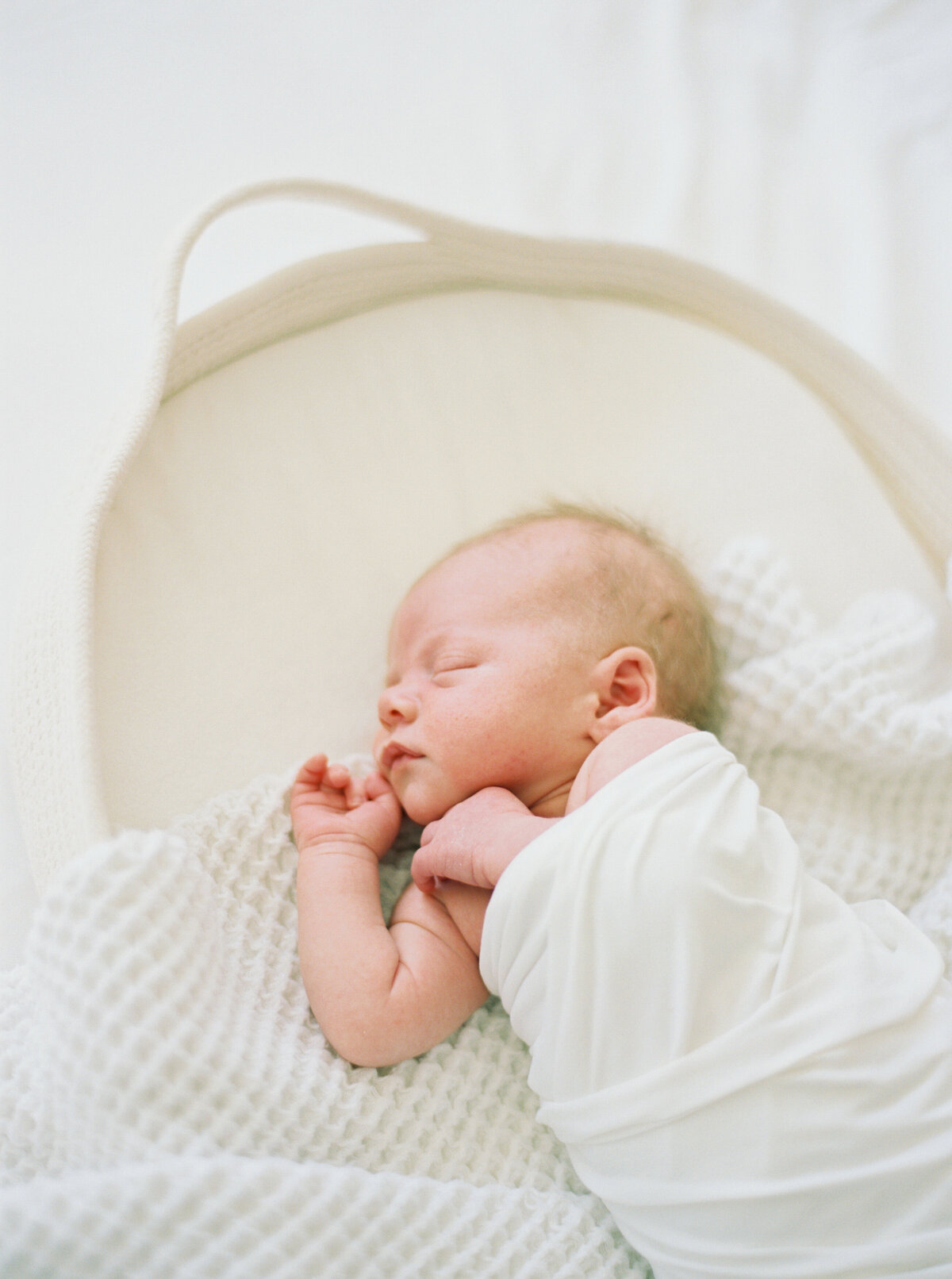 newborn baby boy in all white taken by photographer milwaukee wi talia laird photography