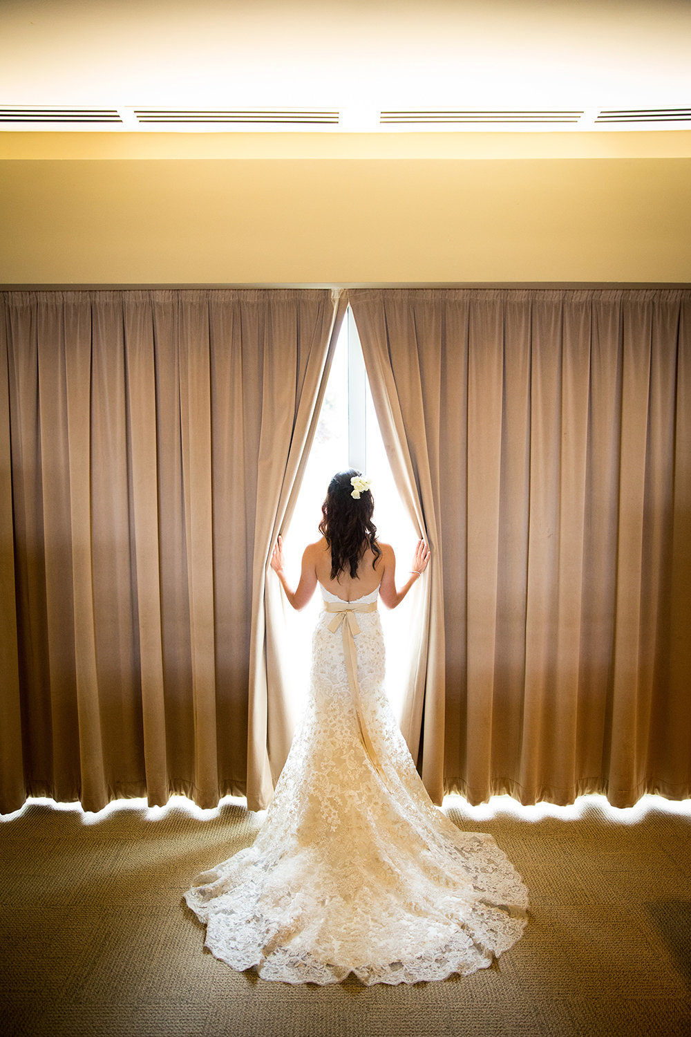 Scripps Seaside Forum bride looking through curtains