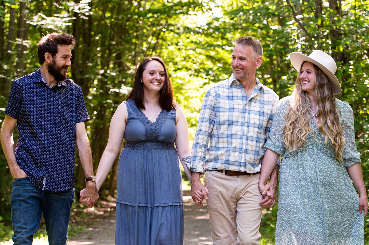 a dad walking and laughing with his adult children in the woods captured by Ottawa Family Photographer JEMMAN Photography