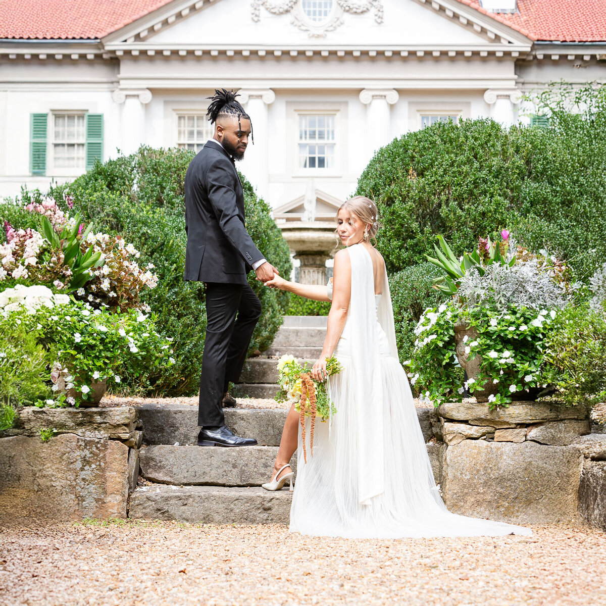 Bride and groom at Hills & Dales Estate in La Grange Georgia, with the bride descending an elegant stone staircase