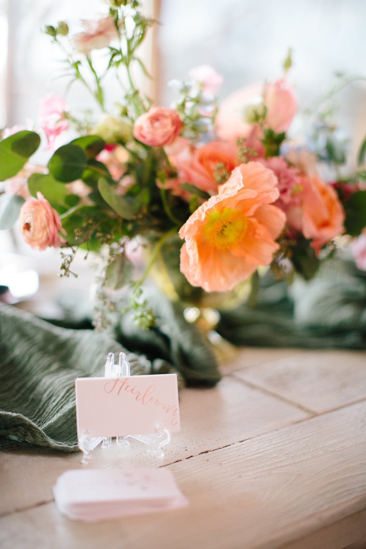 Close up of centerpiece with peach poppy and ranunculus