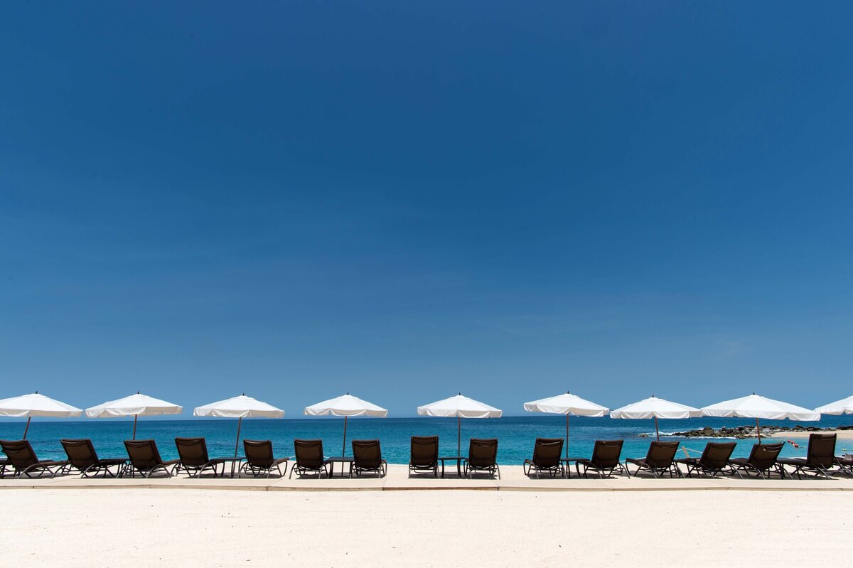 Tropical destination for Incentive Travel events. Recliners with umbrellas facing the ocean shot with beach in foreground and peaceful ocean in background