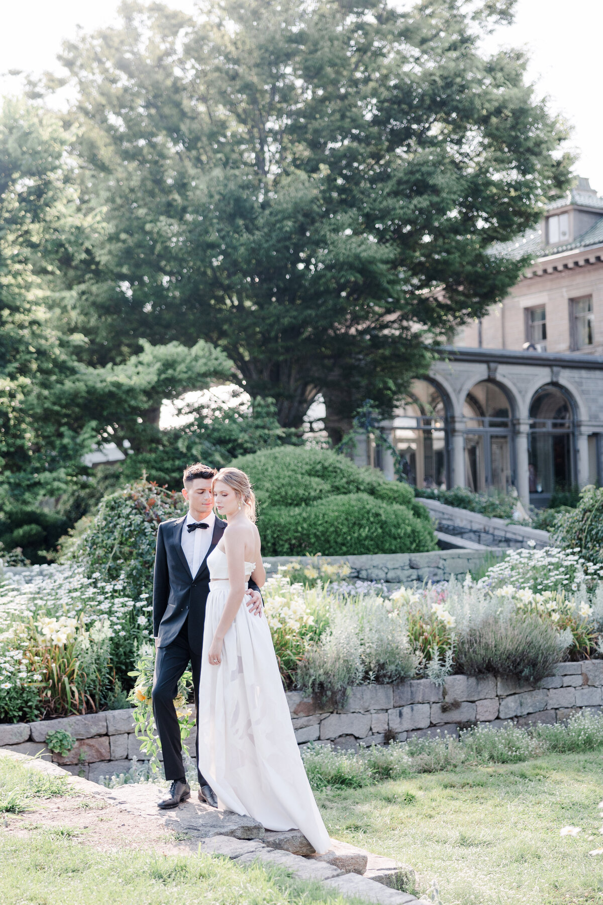 groom and bride walking in gardens at their wedding venue