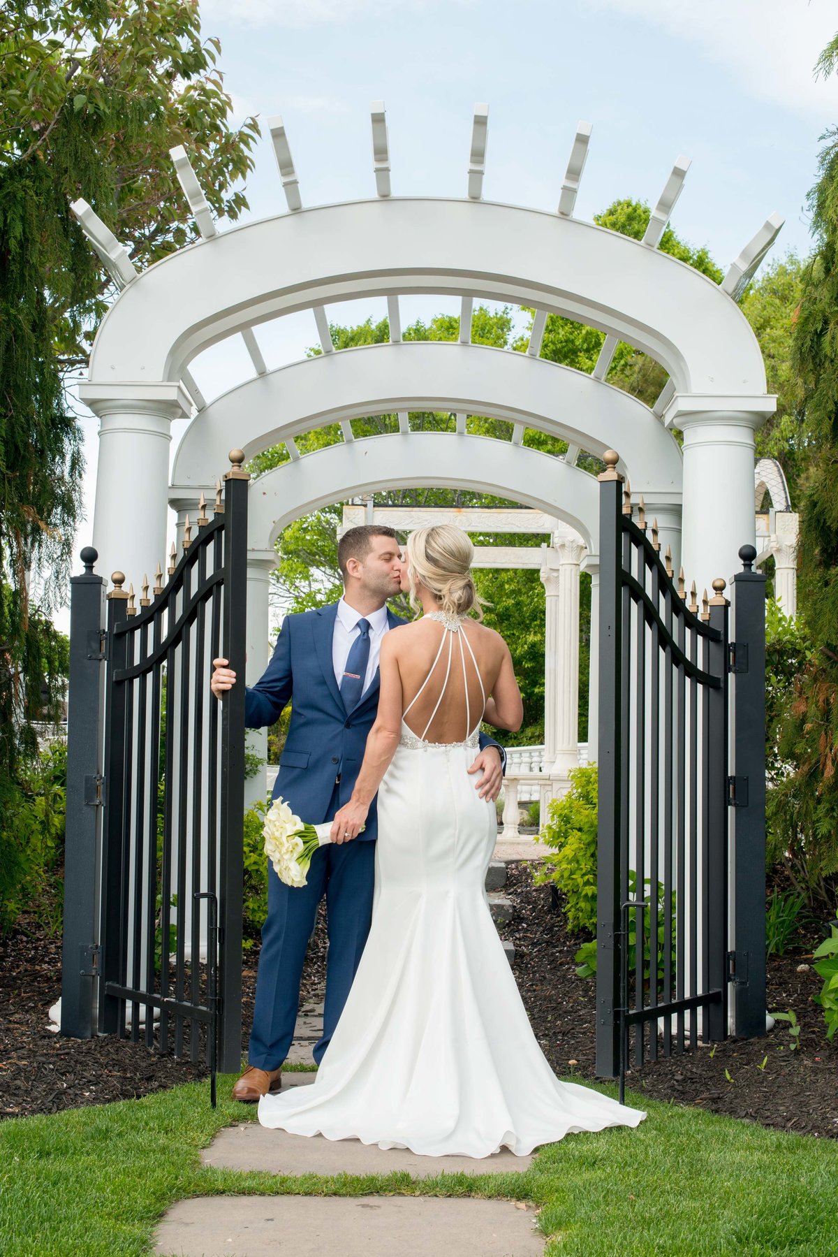 Bride and groom kissing at the gate of Giorgio's Baiting Hollow