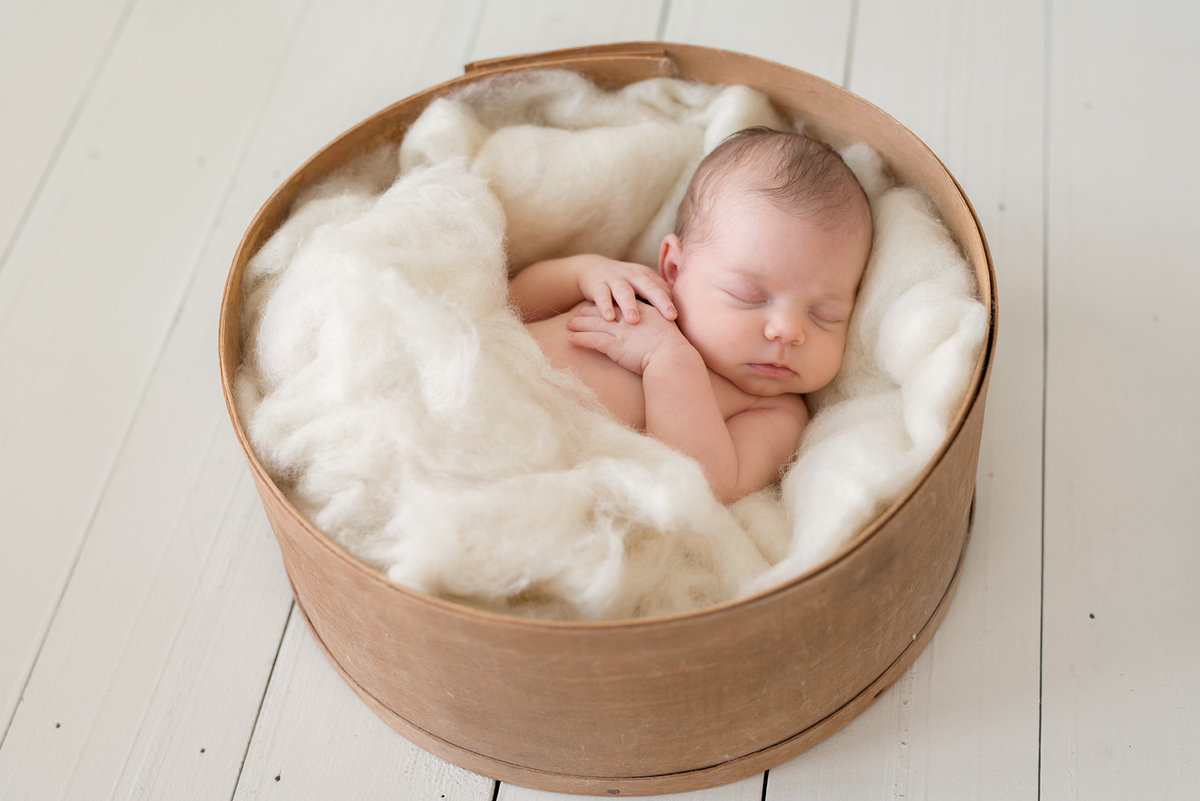 a sweet baby girl sleeping in a basket