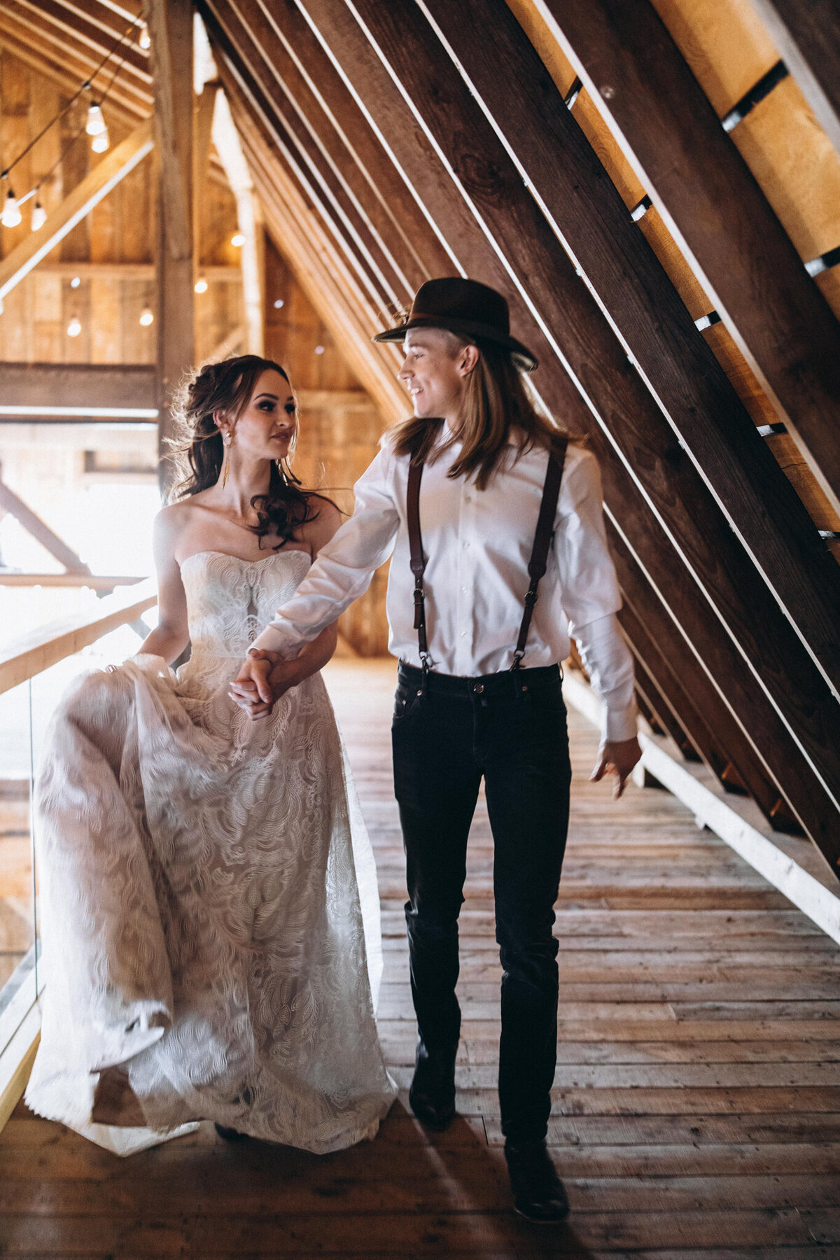 Couple walking hand in hand in the loft at Countryside Barn, a rustic, country Lethbridge, Alberta wedding venue, featured on the Brontë Bride Vendor Guide.