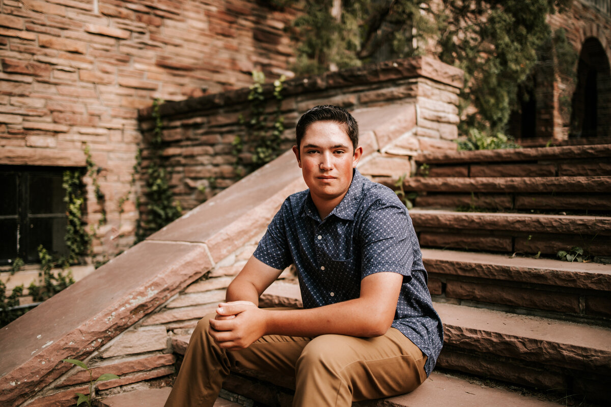 high school boy sits on old vintage cobble stone stairs in boulder colorado