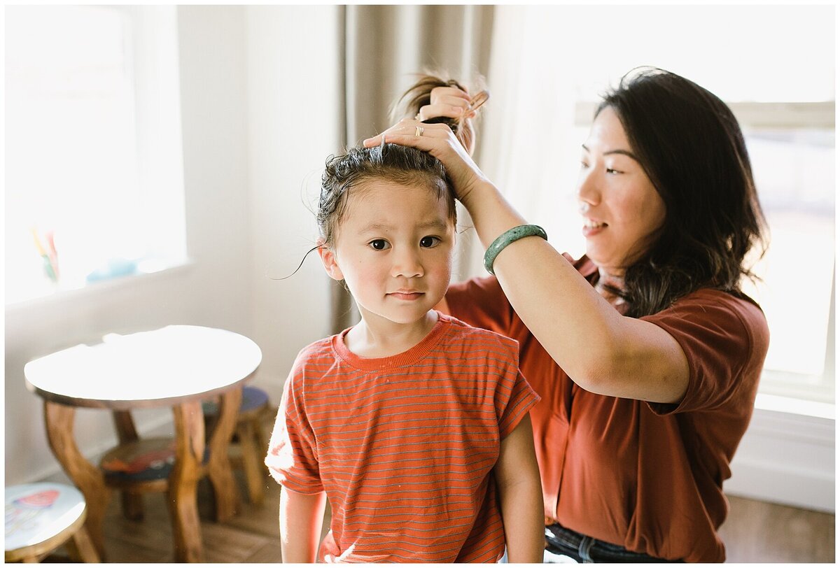 Mother doing daughter's hair at family photo session in Austin by Amber Vickey Photography