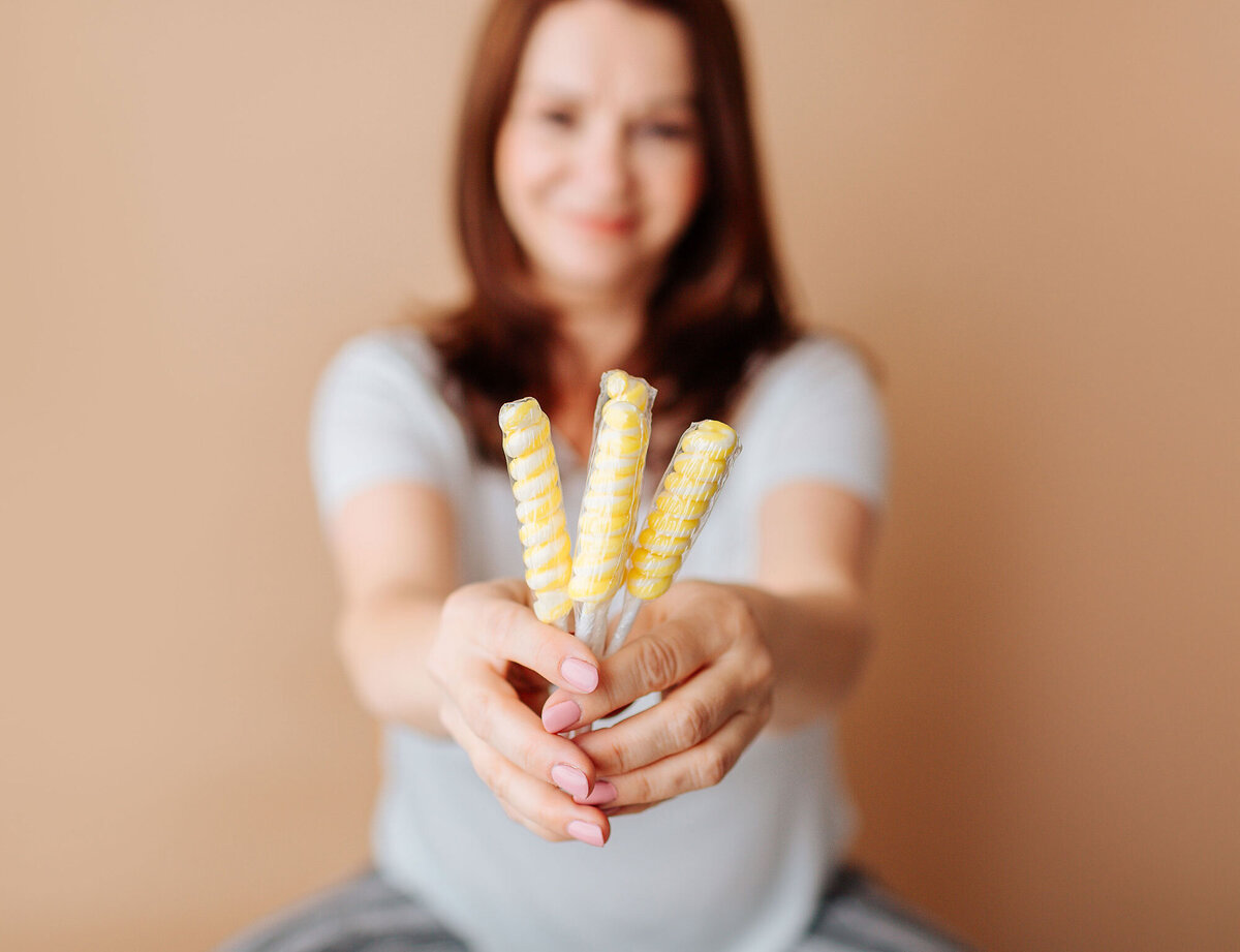 nj photographer holding yellow lollipops